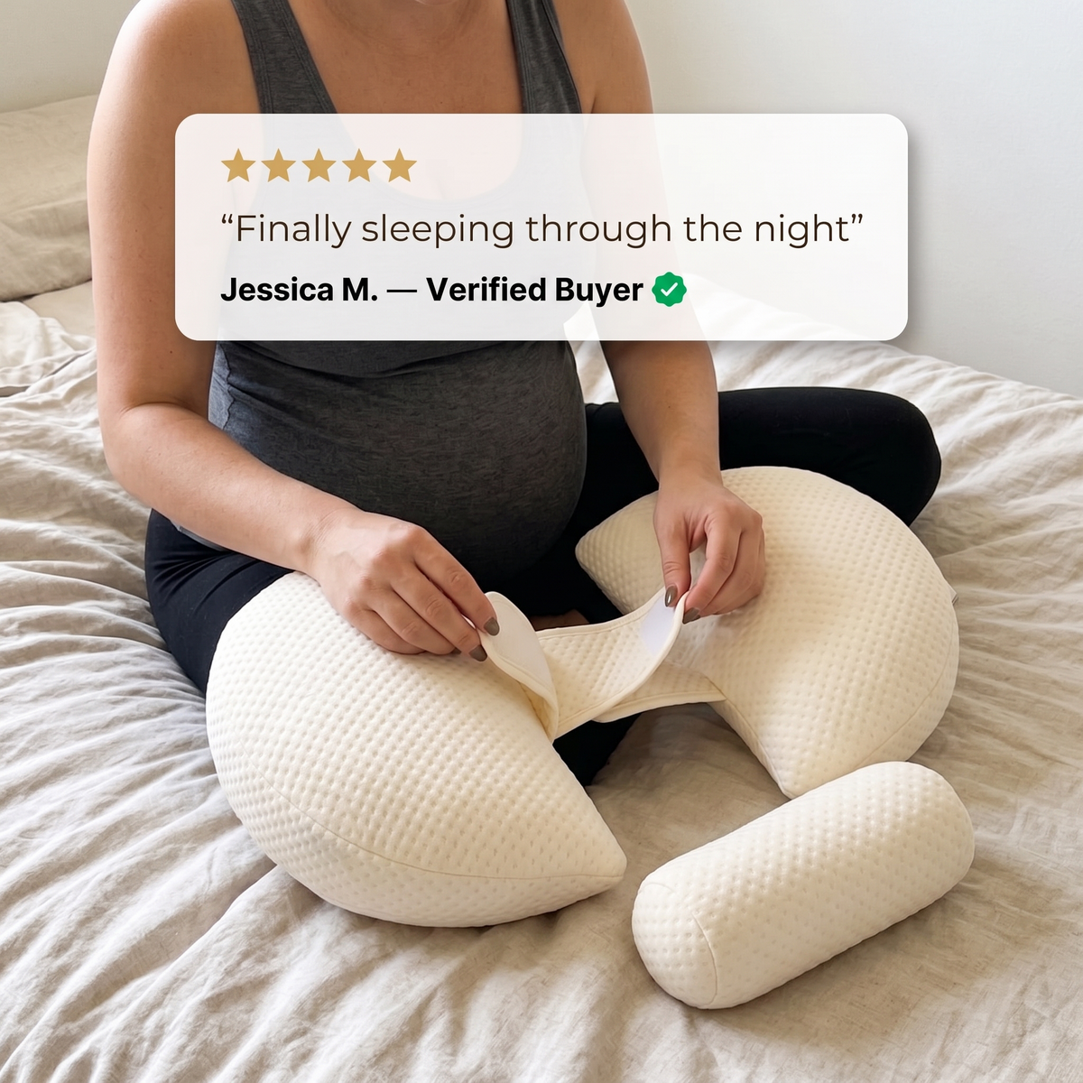 Pregnant woman adjusting the band of Bub's Maternity Pillow on the bed