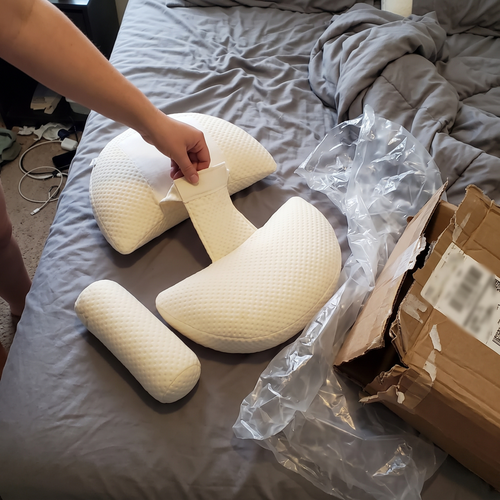 Unboxing Bub's Maternity Pillow on a bed