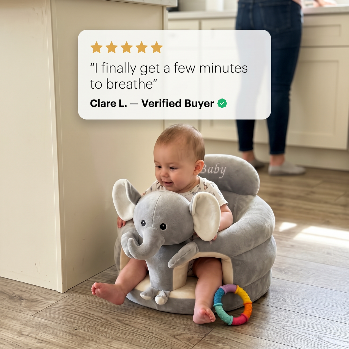 Baby sitting in the Sweet Sleep Essential Baby Lounger elephant on a kitchen floor