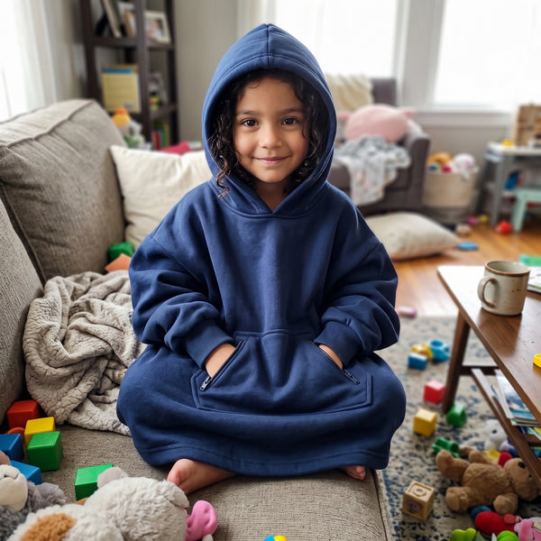 Girl sitting on a sofa in the Sweet Sleep Kids Hug Hoodie