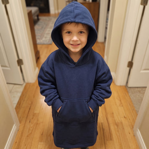 Young boy standing in a hallway in the Sweet Sleep Kids Hug Hoodie