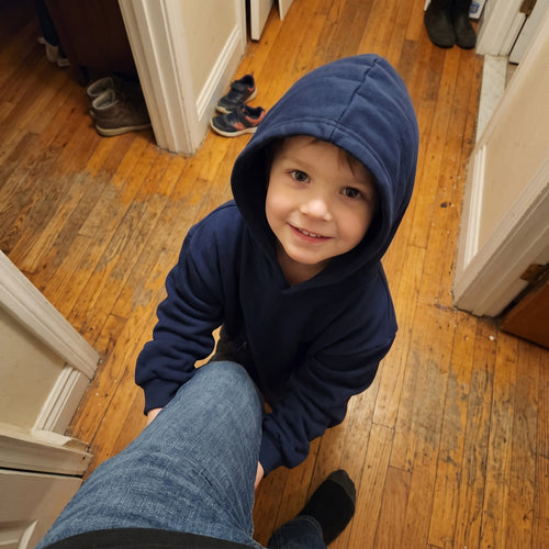 Smiling boy in the Sweet Sleep Kids Hug Hoodie with hood up