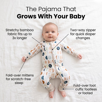 Baby lying on a bed in the Luna Neutral Zippy footie with feature callouts