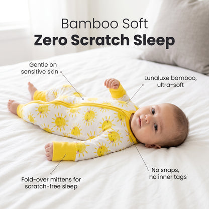 Baby lying on a bed wearing Sweet Sleep Sunshine Zippy footie with feature callouts