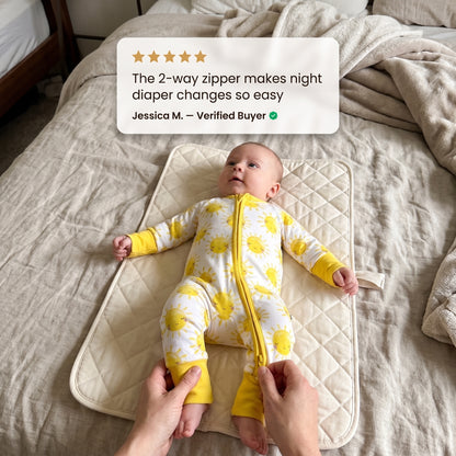 Baby on a changing mat wearing Sweet Sleep Sunshine Zippy with a customer review
