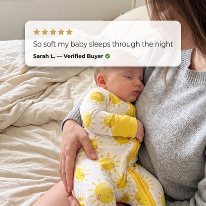 Sleeping baby in Sweet Sleep Sunshine Zippy held by a parent, with a customer review
